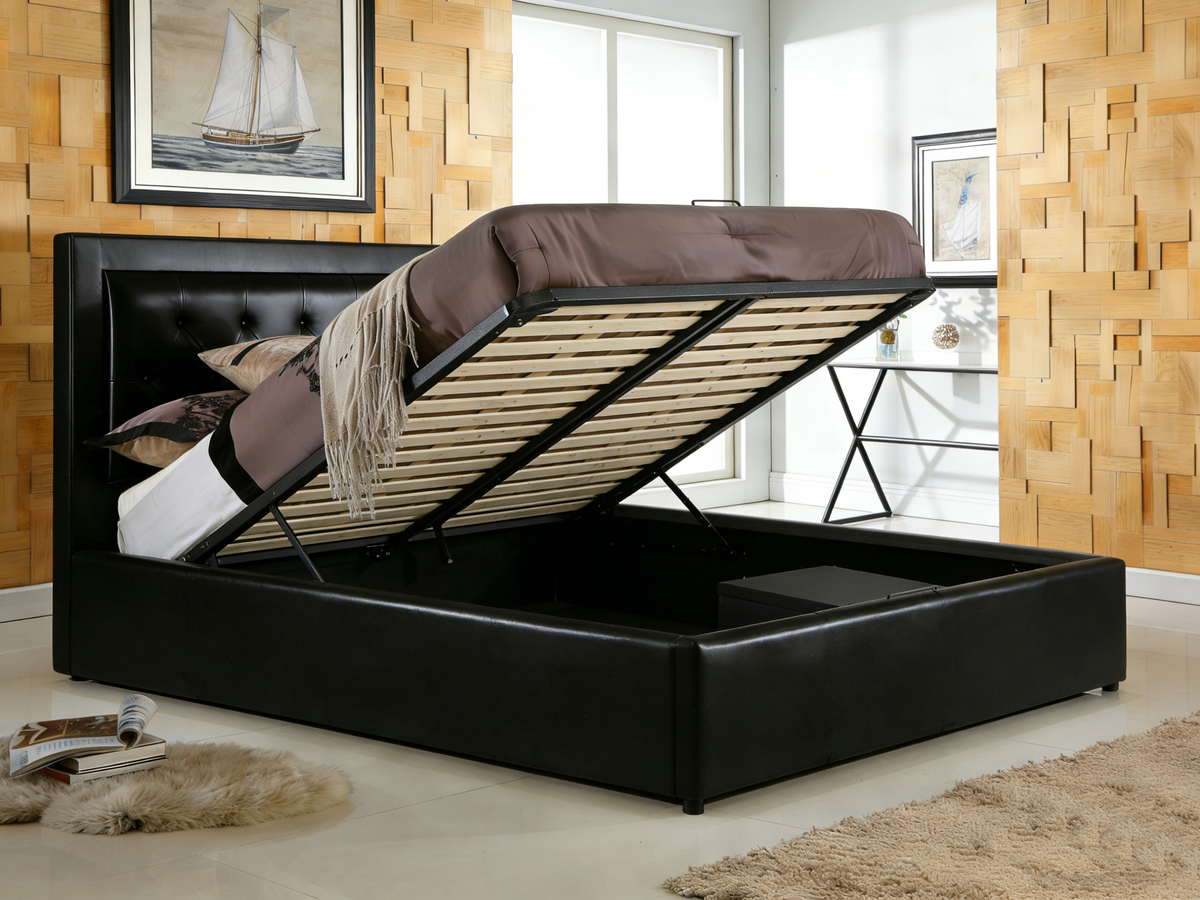 Black upholstered bed with storage compartment in a room with wooden walls and a sailboat painting.