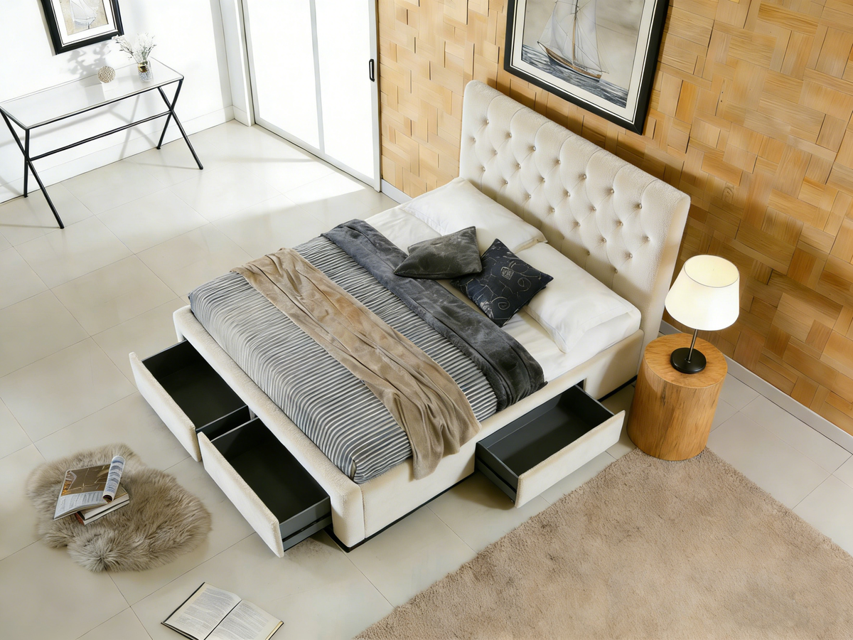 Modern bedroom with a white upholstered bed featuring storage drawers, a lamp, and decor items.