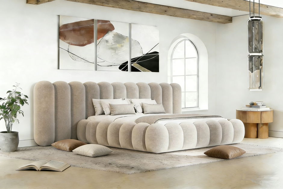 Beige upholstered bed in a modern bedroom with abstract art on the wall.