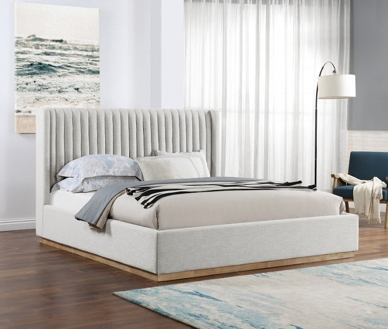 Neatly made bed with gray headboard in a bedroom setting