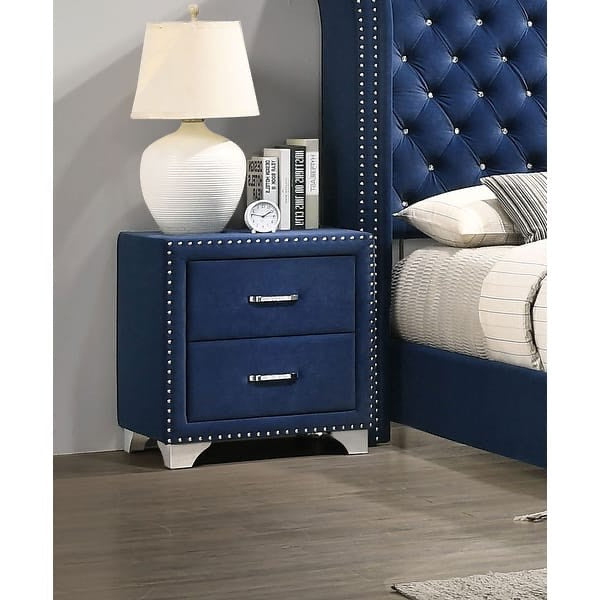 Blue nightstand with two drawers next to a bed with a tufted headboard.